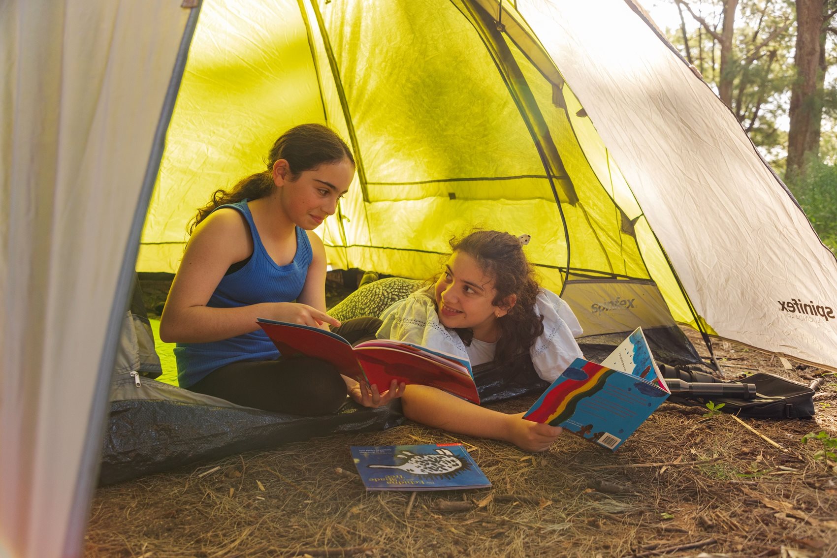 Two girls reading in a tent